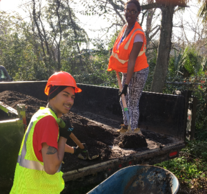 Two workers implement sustainable landscaping in Savannah, Georgia, to create a more sustainable south.