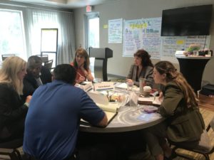 A group of SSDN members sit at a table to discuss sustainability issues.