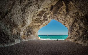 A photo of a cave looking out to a crystal blue ocean and beach for SSDN storytelling program