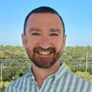 man smiling with trees in the background