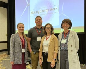 Four people in front of a screen that says Making Energy Work Conference