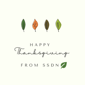 Beige background with colorful leaves text reads Happy Thanksgiving from SSDN