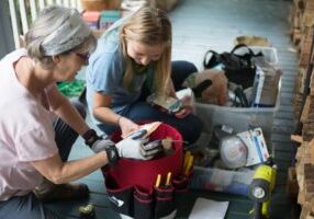 Alice and Yulia with supplies demonstrating weatherization and energy efficiency upgrades in Asheville and Buncombe County, North Carolina.