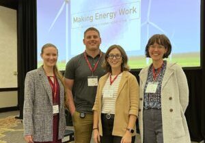 Four people in front of a screen that says Making Energy Work Conference