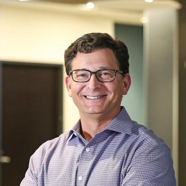 man with dark hair and glasses